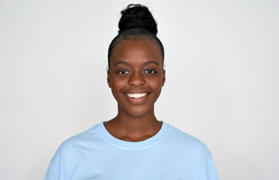 Happy young african american woman wear blue tshirt look at camera isolated on grey background. Positive pretty black ethnic girl with healthy white teeth, dental smiling headshot portrait, close up.