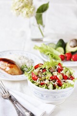 Salad with strawberries, quinoa, avocado, cucumber, lettuce, onions and green peas. vegetarian food.copy space