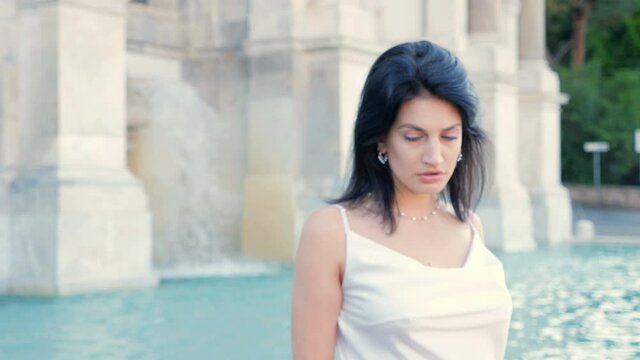 Carefree elegant young woman turning and looking at camera - background