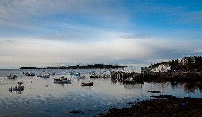 Stonington, Maine;  a cloudy day at Stonington Bay, with boats anchored in the harbor.