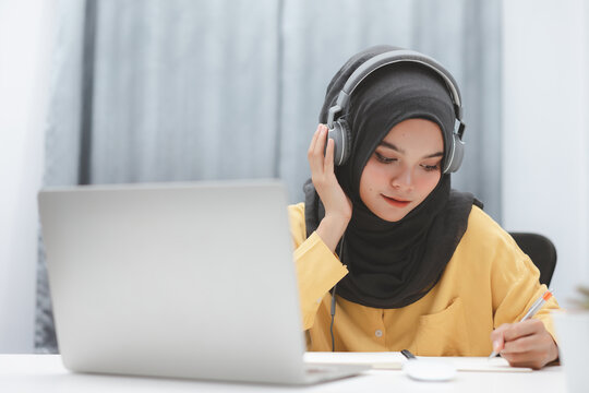 Beautiful muslim student girl using a laptop computer learning online at home. Distance learning online education.