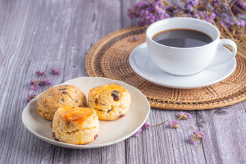 Traditional British scones and cookie with a white coffee cup and blurred background