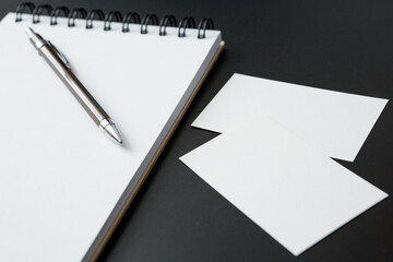 Notebooks , pen and business cards  on black background