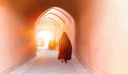 Fototapete Rund Enge Straßen Muslim woman walking on the narrow street of old adobe Yazd city at sunset - Yazd, IRAN  © muratart