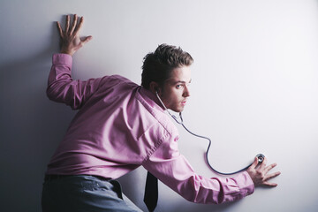 Businessman eavesdropping with a stethoscope