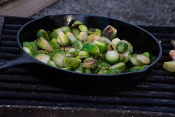 Brussels Sprouts over camp fire in a cast iron skillet 