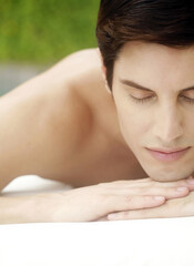Man lying forward on a massage table with his eyes closed