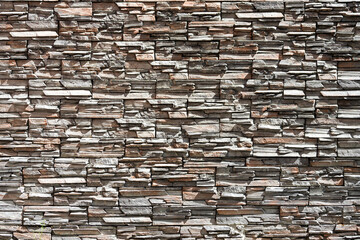 Background of brown-gray stone wall made with blocks . Pattern of slate wall texture and background