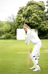 Female cricket player holding a cricket bat