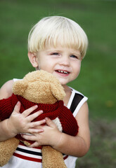 Little boy hugging a toy bear