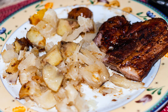 Dish with steaks cooked in a pan with onions, Andean potatoes, fine herbs and spices, accompanied with cassava in brine. Selective focus.