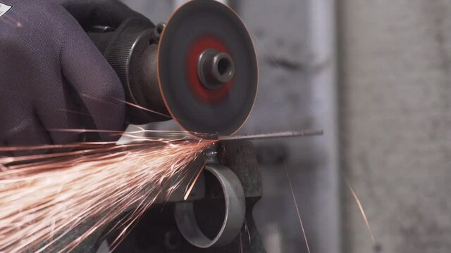 Cutting metal element on the vice with pneumatic rotary cutter in the workshop.