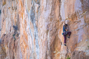 A strong girl climbs a rock, Rock climbing in Turkey.