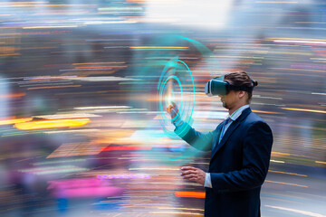 Businessman in elegant suit wearing VR  headset taking part in virtual conference while touch moving future technology concept with bokeh colorful background. 