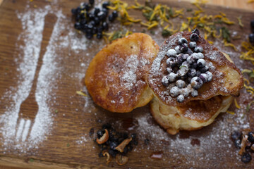 Fototapeta na wymiar Close-up of fritters with fresh blueberries in powdered sugar