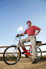 Senior man with safety helmet sitting on a bicycle