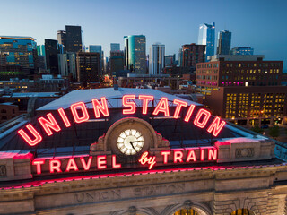union station train station travel by train neon sign with clock and cityscape backdrop in Denver Colorado