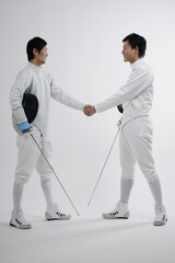 Two men in fencing suits shaking hands