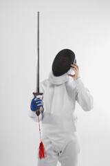 Confused man in fencing suit holding a sword