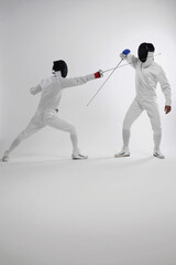 Two men in fencing suits dueling