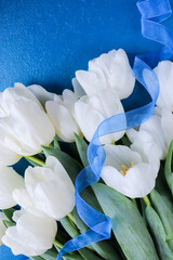 greeting card. A large bouquet of white tulips on a blue background. congratulation. invitation. flat lay