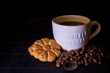 Cup of hot coffee with cookies and coffee beans