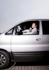Fototapeta na wymiar Businessman talking on the phone while driving in the car