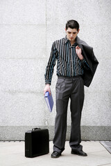 Businessman holding his coat and a document