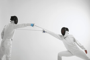 Man in fencing suit attacking his opponent
