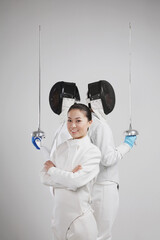 Woman and two men in fencing suits posing for the camera