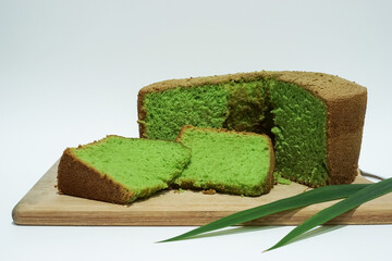 Traditional chiffon green cake on a wooden plate isolated in white background