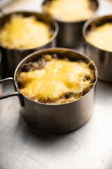 Julienne with chicken, cheese and mushrooms served in small metal bowl. Selective focus. Shallow depth of field.