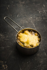 Julienne with chicken, cheese and mushrooms served in small metal bowl. Selective focus. Shallow depth of field.