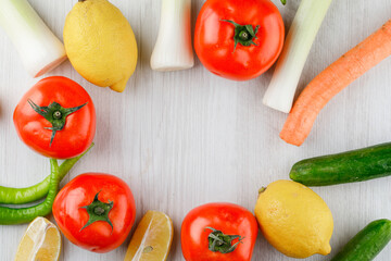 Fototapeta na wymiar Fresh vegetables with lemons on white wooden background, flat lay.