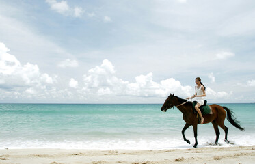 Woman riding a horse on the beach