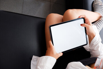 Woman holds tablet in hands. Morning online activities in home. Relax in sofa, watching movies and TV shows on mobile device. Social media addiction. Work at home, freelance. Technology in lifestyle