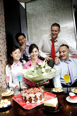 Naklejka premium Business people throwing a surprise birthday party for their female colleague