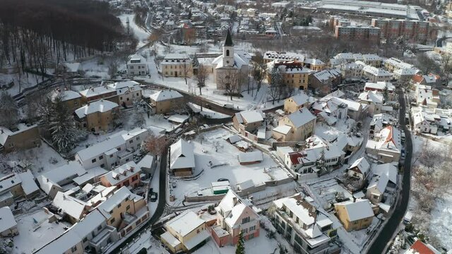 Bird's eye view of the Liboc city district in Prague. The church of the St. Fabian and Sebastian standing on the hill above the houses. Fresh snow covering roofs, walkways, and lawns.
