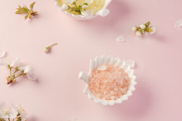 Sea salt for baths in porcelain plates on pink paper background as Spa and personal care concept