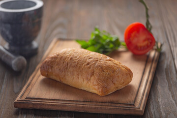 Ciabatta vegetables greens on kitchen board, close up