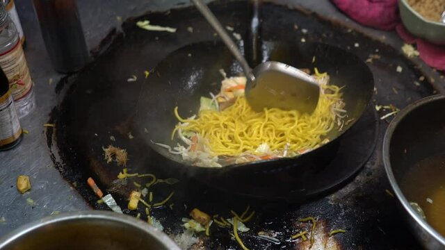 Cooking Noodles With Vegetables On The Messy Stove In Chinatown, Bangkok, Thailand - close up