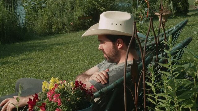 man in cowbow hat relaxing in summer