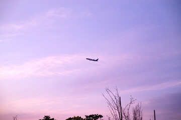離陸後、上昇旋回する飛行機と夕焼け空