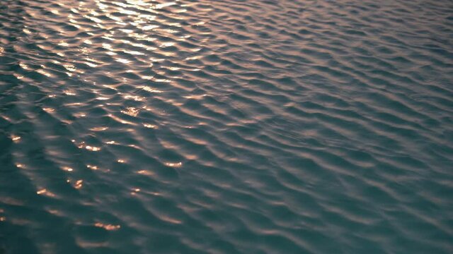 clear water with small wavelets and sun reflections. Sea water nature background.