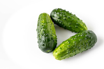 A few fresh green cucumbers on a light background. The concept of natural food. Selective focus.