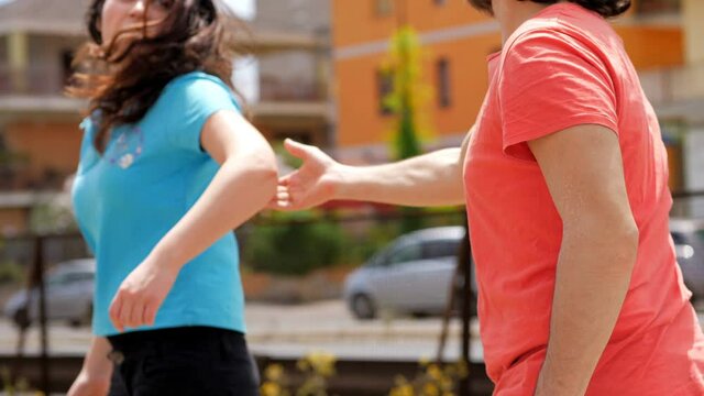 back view of young man trying to stop his girfriend who is leaving