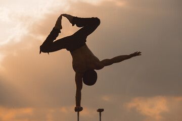 performance of an aerialist outdoors during sunset.