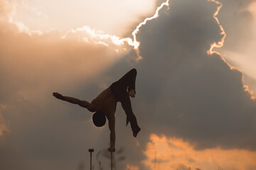 performance of an aerialist outdoors during sunset.