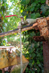 Running water from the rusty water tap in the garden