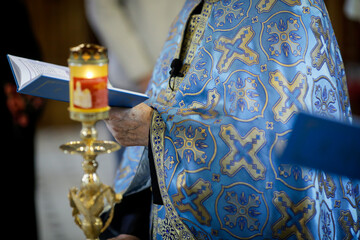Details of an Orthodox priest reading from the Holy Bible during an Orthodox Baptism.